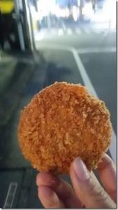 メンチカツを手に持っている写真